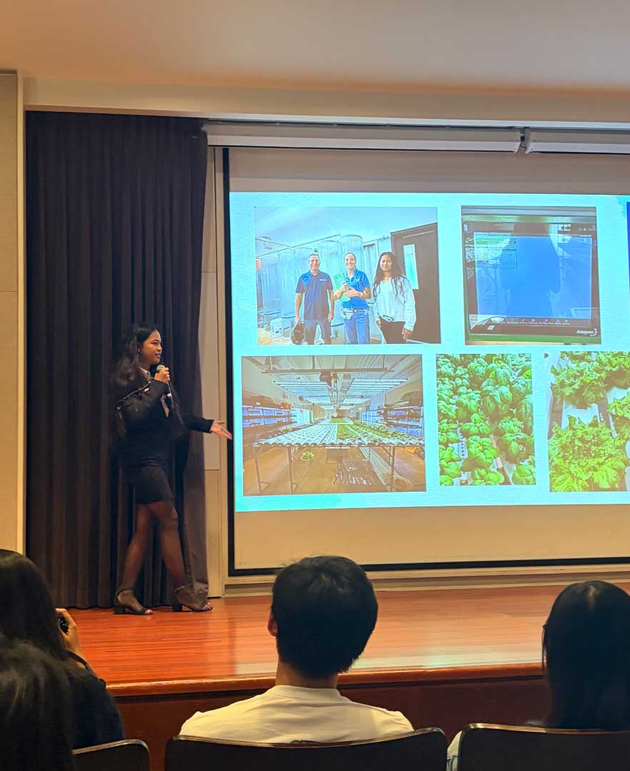 Student presenting NSEVP youth engagement and indoor hydroponic growing project results to an audience, with grow room and crop images displayed on screen.